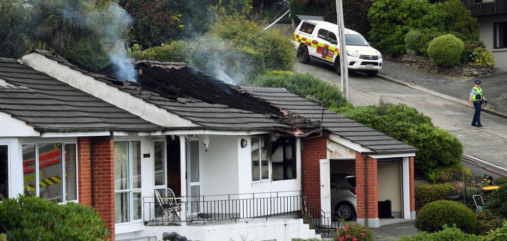 Smoke rises from the damage caused by a house fire in Challis St which left one person dead. Photo: Stephen Jaquiery