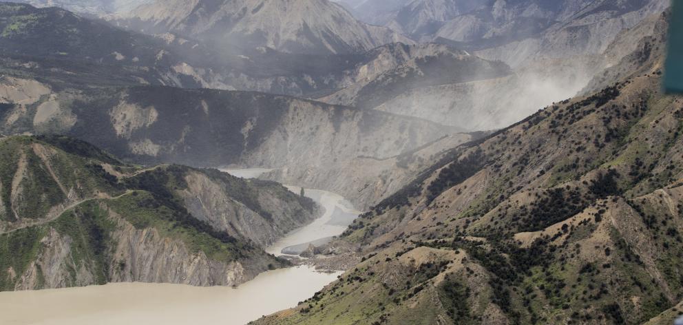 Dust created by a strong aftershock hangs above the Clarence River, which was blocked, causing a...