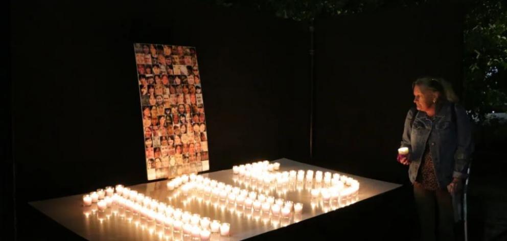 Julie Abraham has a quiet moment of reflection at the vigil. Photo: RNZ