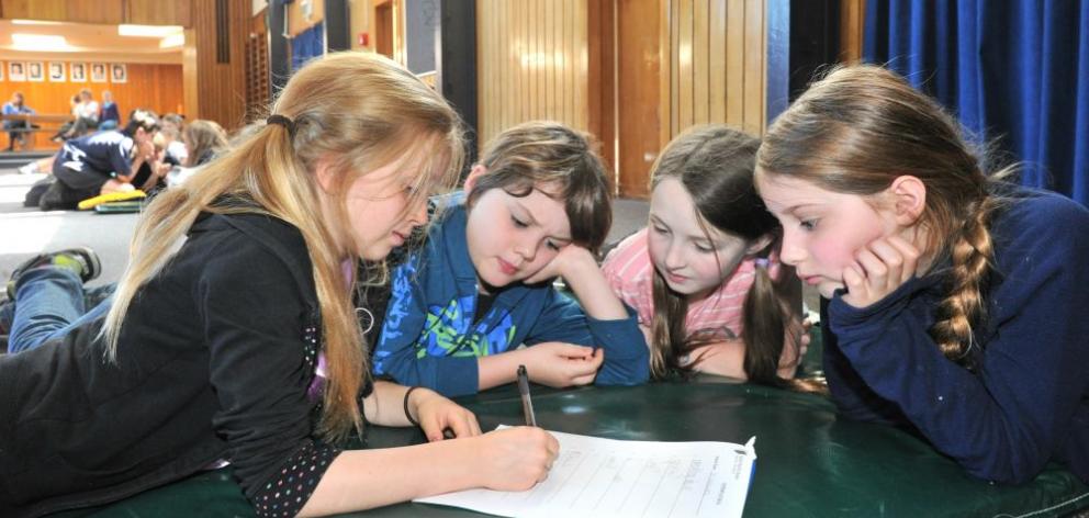 St Leonards School pupils (from left) Sophie Bradfield, Tane Cotton, Isabel McMillan and Sophie Davison (all 10) record their answers during the Dunedin Kids' Lit Quiz at Dunedin North Intermediate yesterday. Photo by Linda Robertson. 