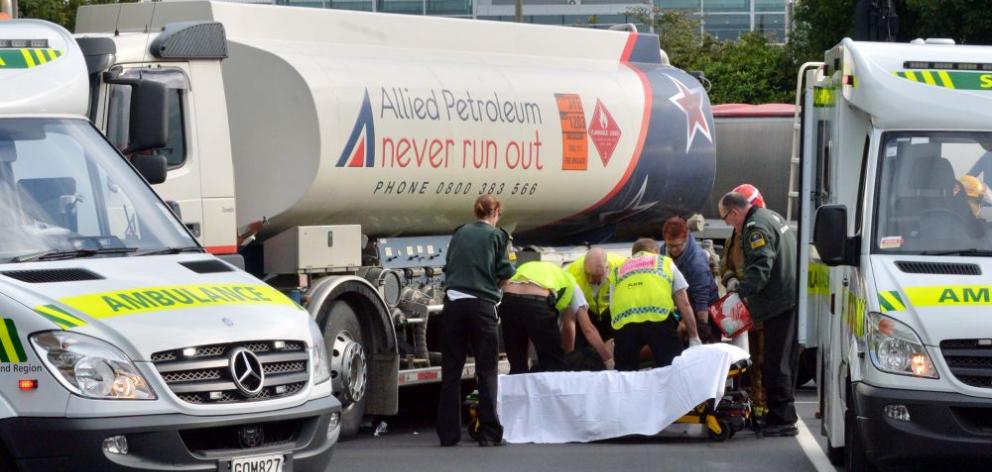 Emergency services assist a pedestrian knocked down by a petrol tanker yesterday morning. 