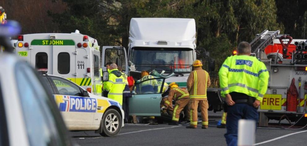 Emergency services work to free  a car driver in a critical condition after the vehicle and a truck  collided  near the intersection of State Highway 1 and Henley Rd yesterday. Photo by Craig Baxter. 