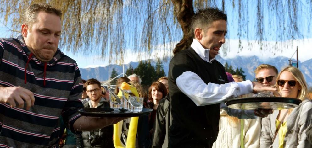 Frazer Currie (Queenstown Resort College), left, and Diego Moyano  (St Mortiz)  concentrate in the Queenstown Winter Festival waiters' race yesterday. Photo by Stephen Jaquiery. 