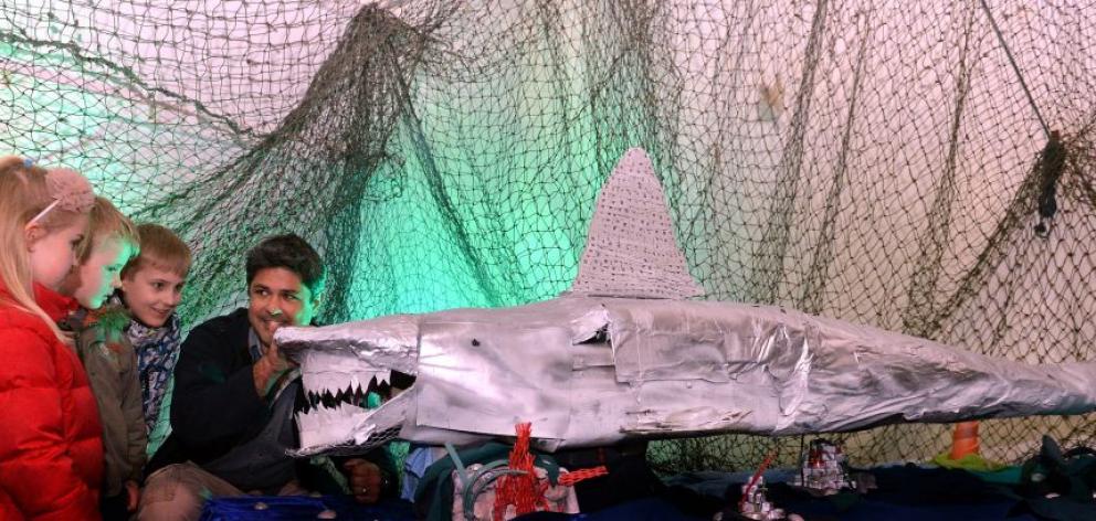 Marine explorer and documentary film-maker Ryan Johnson, of South Africa, discusses sharks yesterday with (from left) Isla (6), Adam (4) and Theo Nicholson (9) at the New Zealand International Science Festival. Photo by Peter McIntosh.