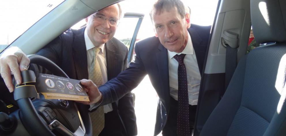 New Zealand Transport Agency southern regional director Jim Harland (left) and Rental Vehicle Association chief executive Barry Kidd fit the first steering wheel tag to a rental vehicle at Queenstown Airport yesterday. Photo by Tracey Roxburgh