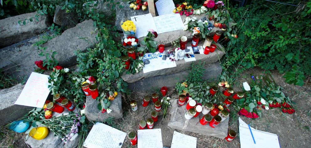 Messages of mourning, candles and flowers are placed by people for Susanna Feldman. Photo: Reuters