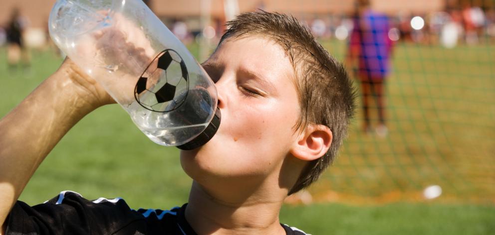 Make sure children get plenty of water when taking part in sport. Photo: Getty Images 