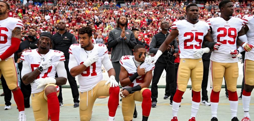 From left:  Eli Harold,  Arik Armstead and  K'Waun Williams of the  San Francisco 49ers kneel...