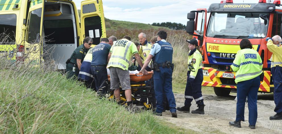 Emergency services prepare to put the man into an ambulance. Photo: Peter McIntosh