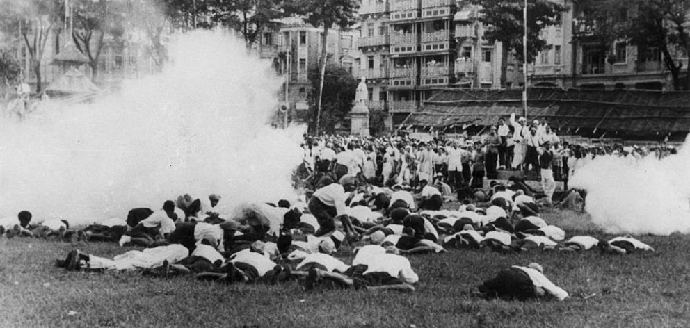 Demonstrators lie on the ground to avoid tear gas released by police when they refused to...
