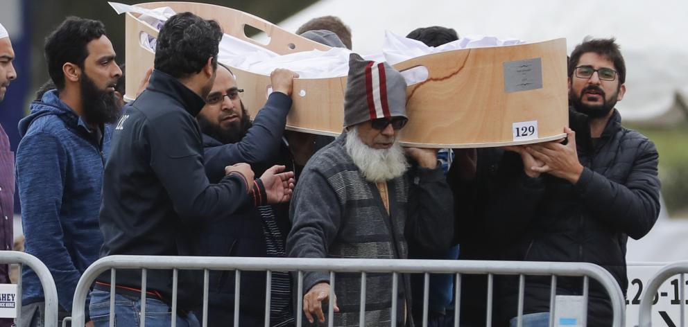 Mourners carry one of 26 people to be buried at Memorial Park Cemetery today. Photo: AP