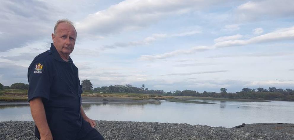 Detective Senior Sergeant Martin James at the rivermouth where the body was found this morning....