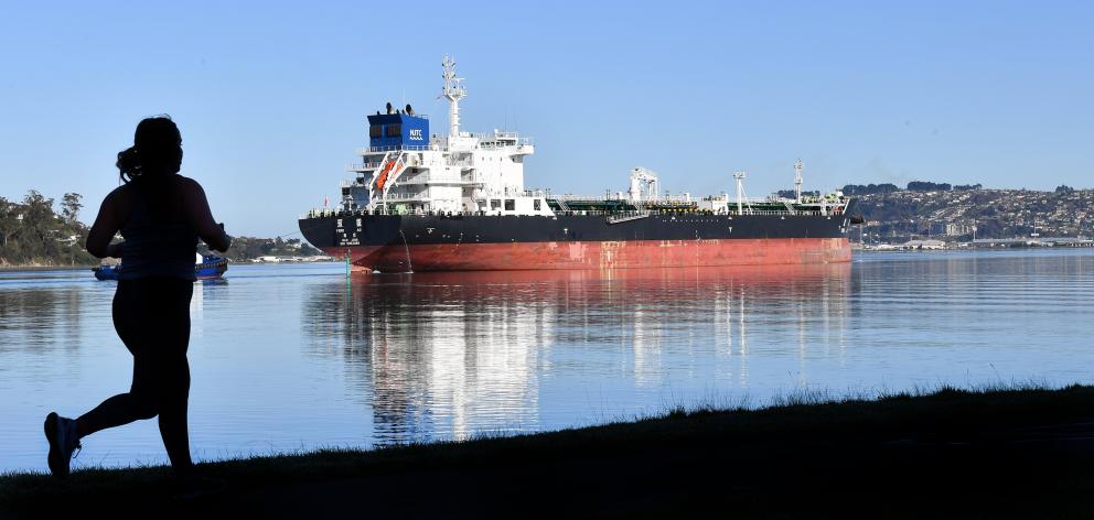 A runner paces fuel tanker Yong Ao as it enters the upper Otago Harbour yesterday. Sailing under...