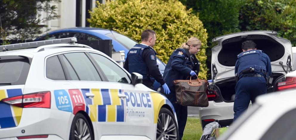 Police search a white late-model BMW in Corunna St before the vehicle was towed away following a...