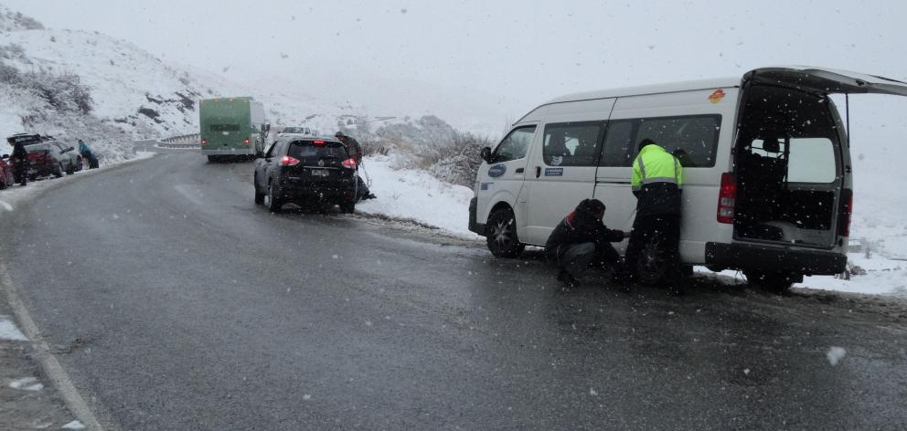 Motorists put chains on their vehicles on the Coronet Peak Road, near Queenstown, this morning. Photo: David Williams Motorists put chains on their vehicles on the Coronet Peak Road, near Queenstown, this morning. Photo: David Williams