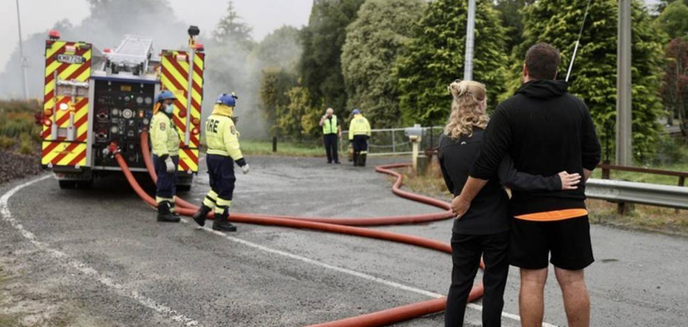 A couple watch on as firefighters battle the blaze. Photo: George Heard / NZH
