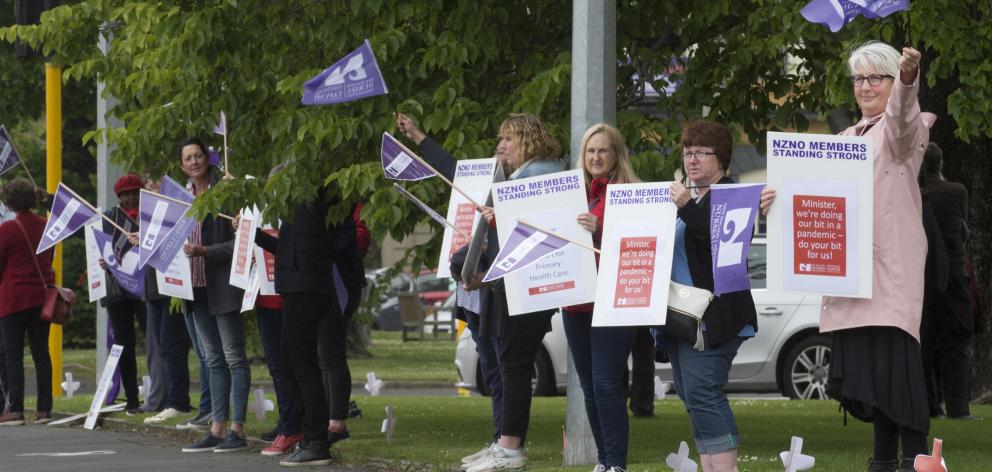 Primary care nurses form a ring around Queens Gardens in Dunedin yesterday in support of their...