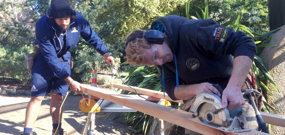 Highlanders loose forward Jackson Hemopo (left) helps Seaview Cottage Construction senior foreman...