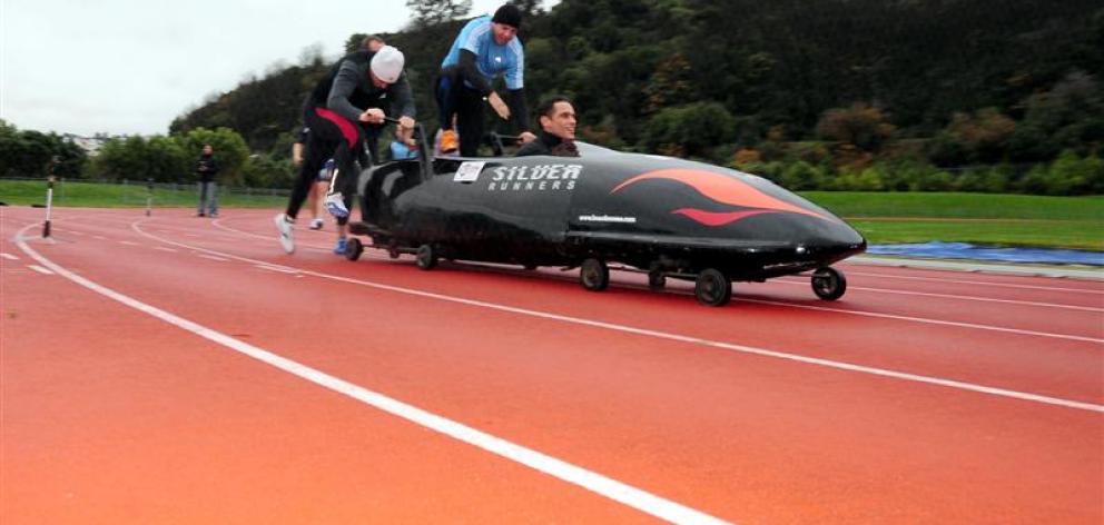 Chris Donaldson steers as Sam Higgie (left), Mark Keddell (obscured) and Don MacDonald push the...