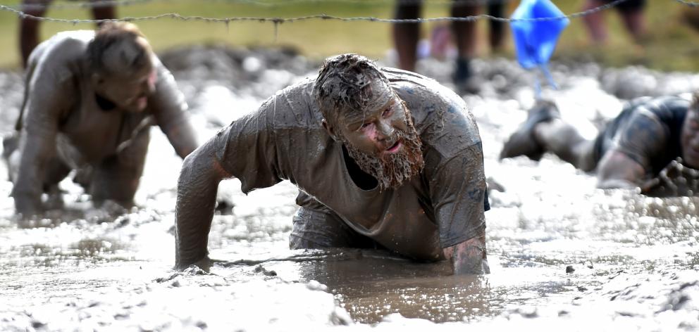 A pool of mud and challenging strands of barbed wire are a recipe for enjoyment for (from left)...