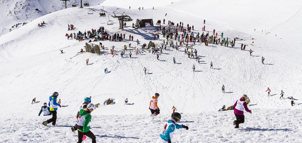 Peak to Peak competitors run to the start of the ski leg at The Remarkables skifield on Saturday....