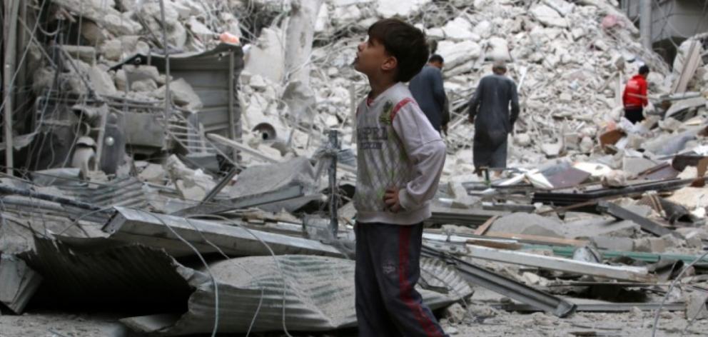 A boy looks at a damaged site after airstrikes on the rebel held Tariq al-Bab neighbourhood of...