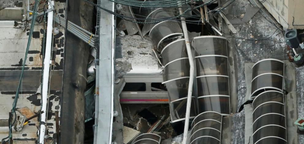 The derailed train is seen under the collapsed roof of the station. Photo Reuters

