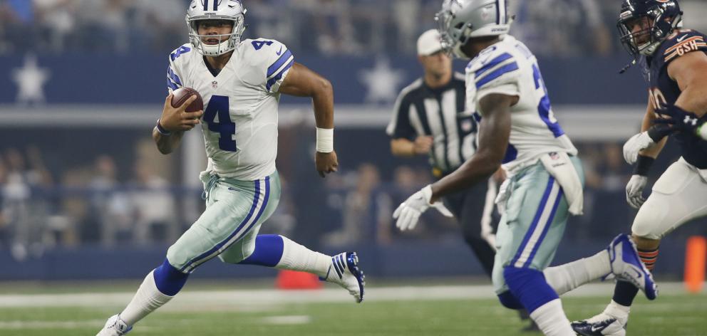 Dallas Cowboys quarterback Dak Prescott (4) scrambles for a first down in the first quarter...