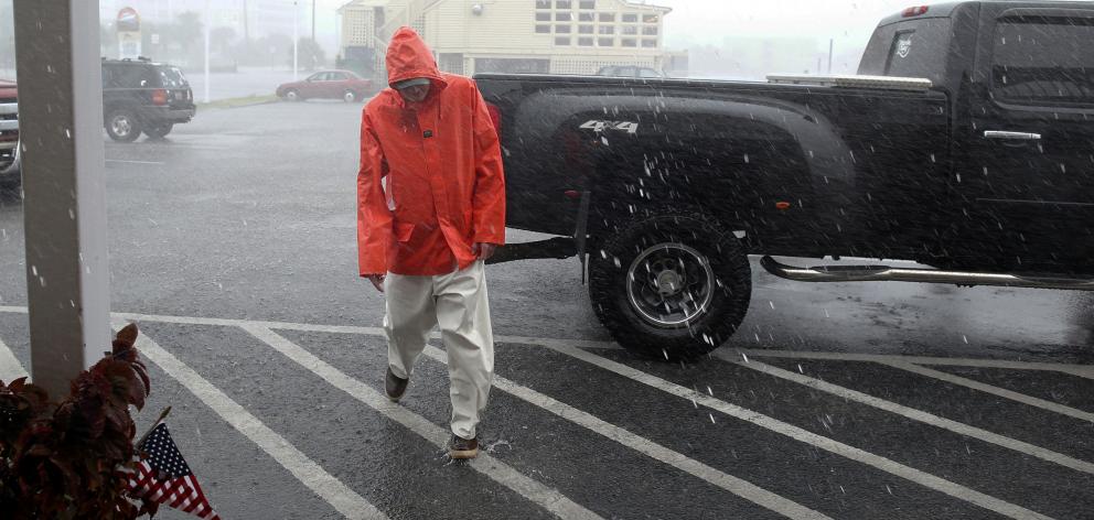 Dave Christian, a dock worker at Marlin Quay Marina, walks through heavy rains caused by Tropical...