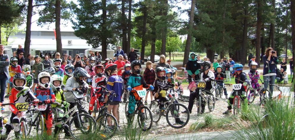 The riders wait for the opening formalities to be over so they can head around the track again. 