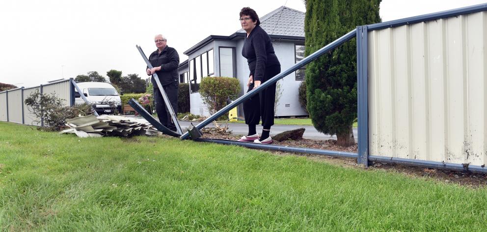 Bill and Pauline Overton inspect the damage to their fence caused when a car ploughed through it....