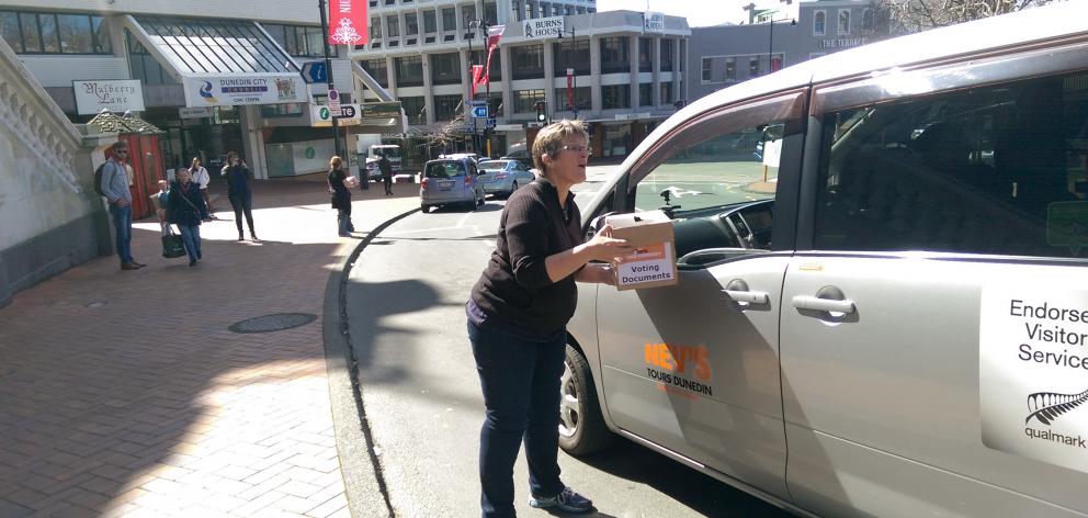 Dunedin City Council chief executive Dr Sue Bidrose collects a last minute voter's paper outside...