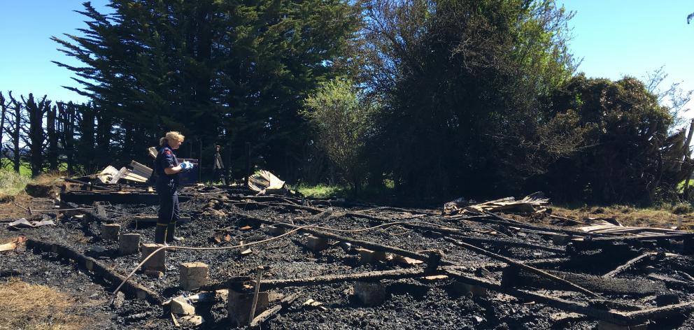 A firefighter examines the remains of the old church destroyed by a fire in Riverton. Photo: Ruby...