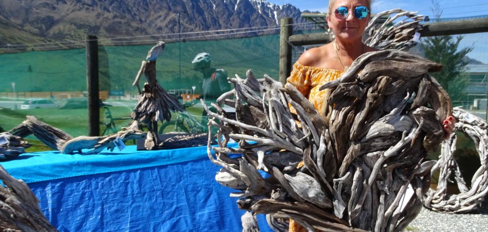 Driftwood artist Maree Maclot holds a piece of her work at the Remarkables Market, which opened...