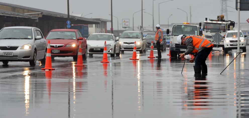 Downer staff drain water from Portsmouth Dr in Dunedin yesterday. Photo by Stephen Jaquiery.