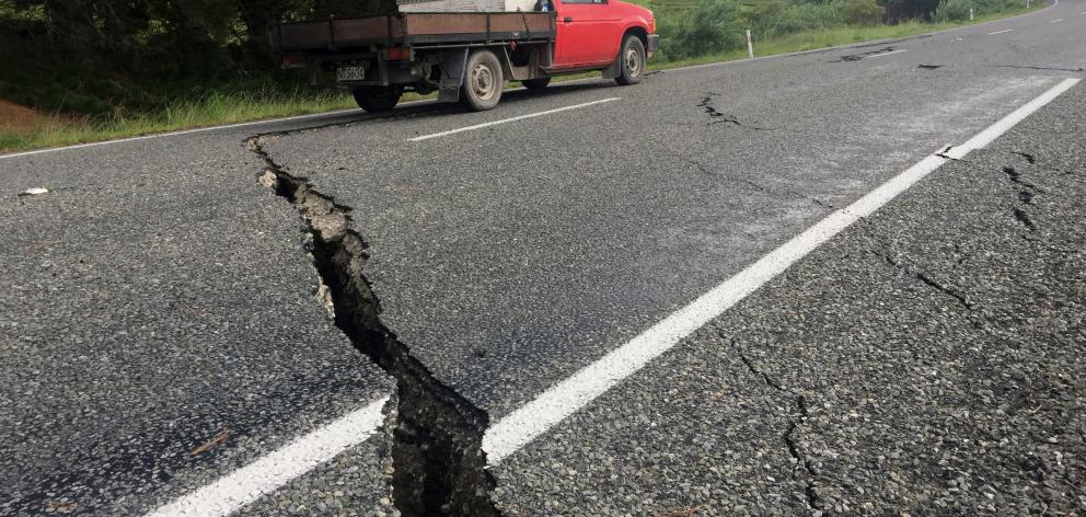 A truck drives over the fractured road caused by an earthquake south of the town of Ward. REUTERS...