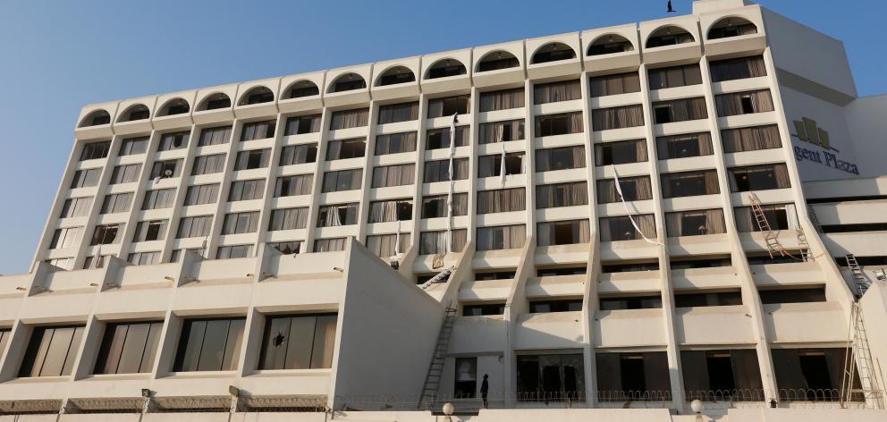 The Regent Plaza hotel in Karachi, showing broken windows and the bed sheets guests used to...