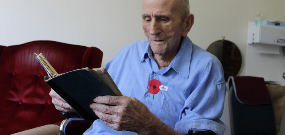 Cromwell centenarian Jack Robertson reads through his World War 2 Bomber Command logbook. Photo:...