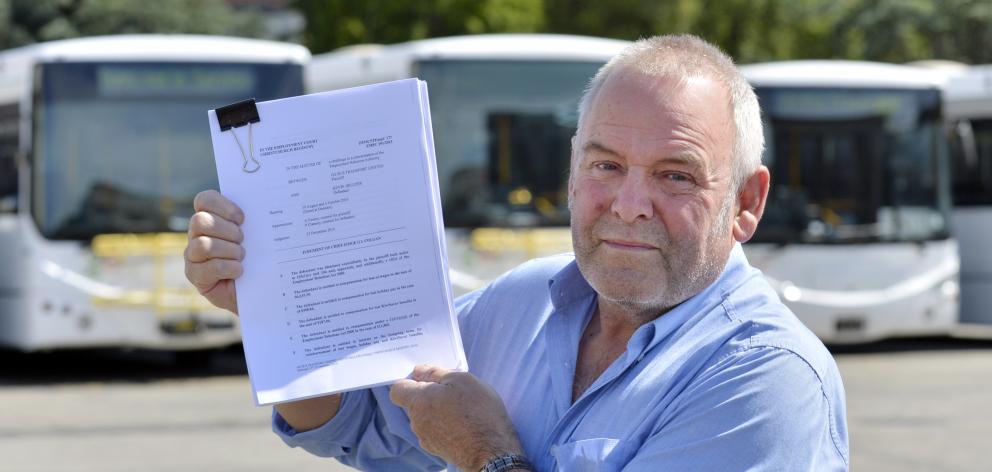 Kevin Hellyer holds the Employment Court judgement outside the Go Bus Transport depot in Dunedin...