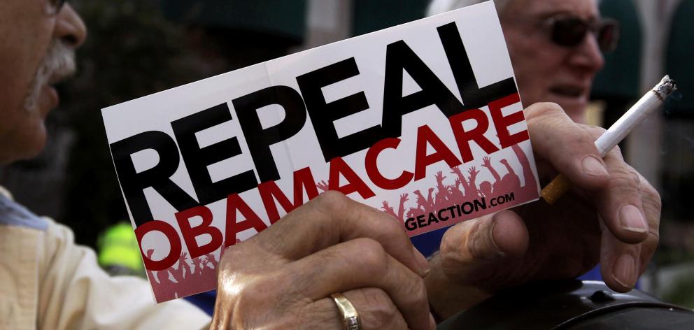 A demonstrator holds a pamphlet outside a ``Defund Obamacare Tour'' rally in Indianapolis. Photo from Reuters.