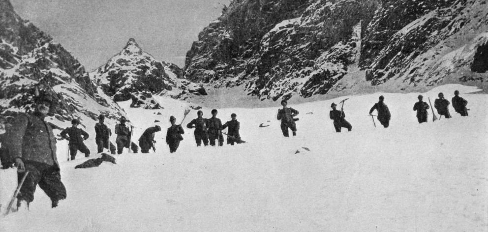 Italian Alpini troops clearing a way across a snow-covered saddle in the Dolomites. — Otago...