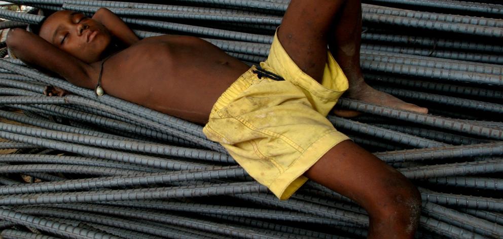  A Bangladeshi flood victim rests on iron rods beside a busy street in Dhaka, which was number 7 on the list of least publicised crises in the world for 2016. Photo: Reuters 