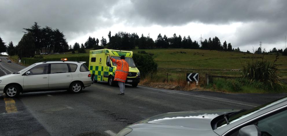 A man directs traffic on Taieri Rd, Halfway Bush, following a crash at Three Mile Hill this afternoon. Photo: Margot Taylor