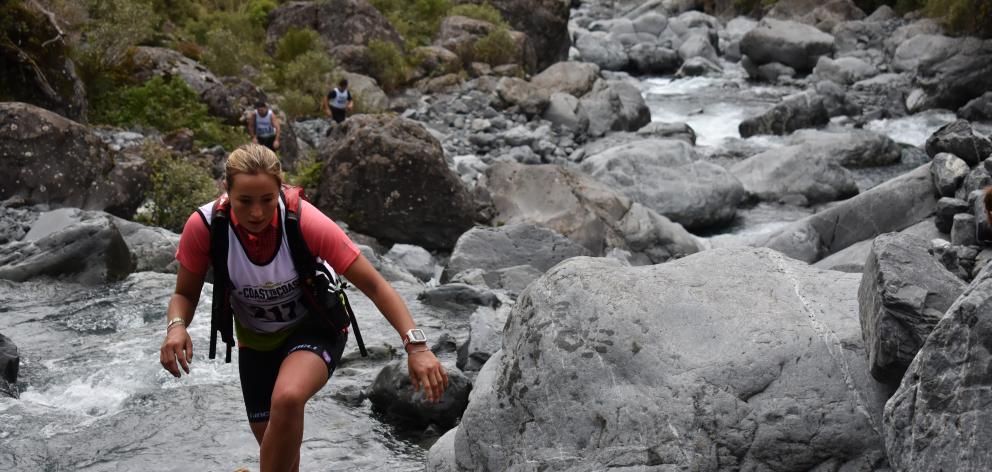 Shannon Edgar negotiates her way through a stream in the Coast to Coast event yesterday. Photo:...