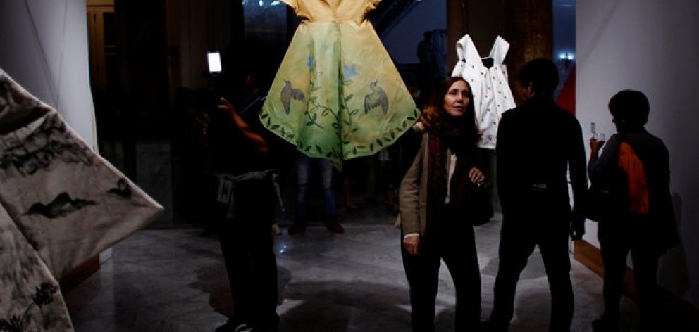 Mariela Castro, daughter of Cuba's President Raul Castro stands next to at a painting on a dress...