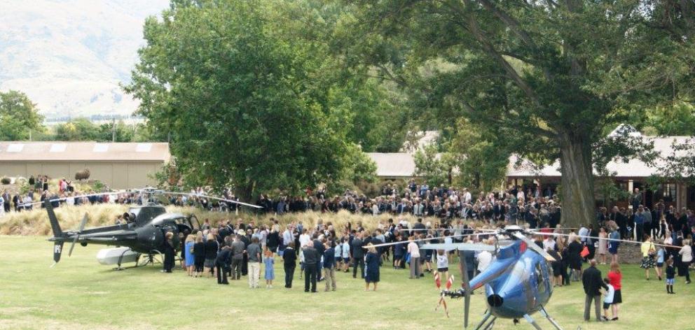 Mourners gather as two helicopters prepare to lift the casket of Cromwell teacher Anne Cook from...