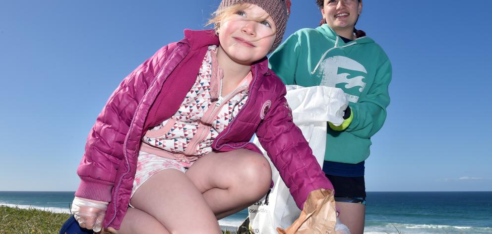 Avana (7, left) and Trinity (16) Martika, of Mornington, pick up rubbish from John Wilson Ocean...
