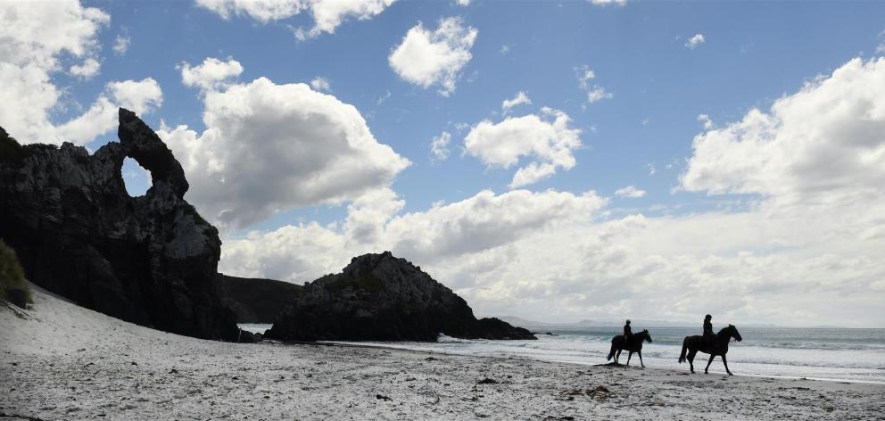 Cheryl Mangan (left) and Eli Cumming ride past Keyhole Rock at Aramoana yesterday, as the Dunedin City Council considers new rules for horses on the city’s beaches. Photos by Peter McIntosh.