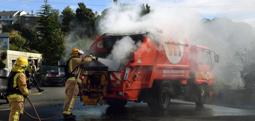 Firefighters tackle a blaze in the back of a Waste Management rubbish truck in Graham St, Dunedin, yesterday morning. Photo by Stephen Jaquiery.