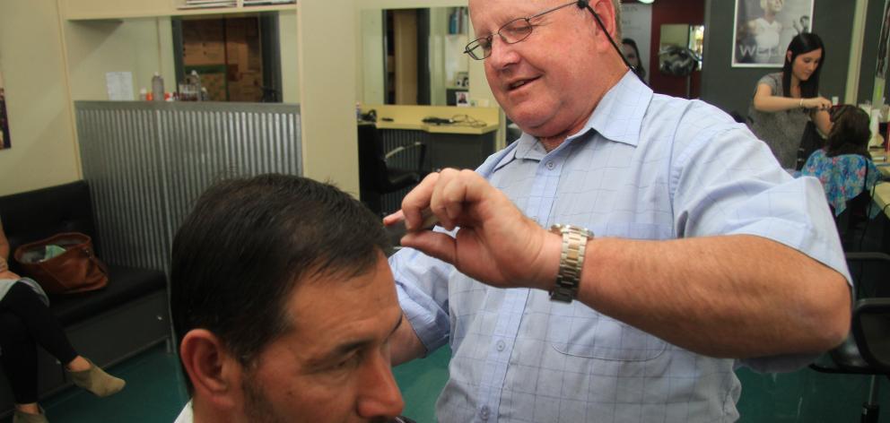 Lower Thames St mainstay Ali Brosnan cuts Ian Moore’s hair yesterday afternoon. Mr Brosnan has...